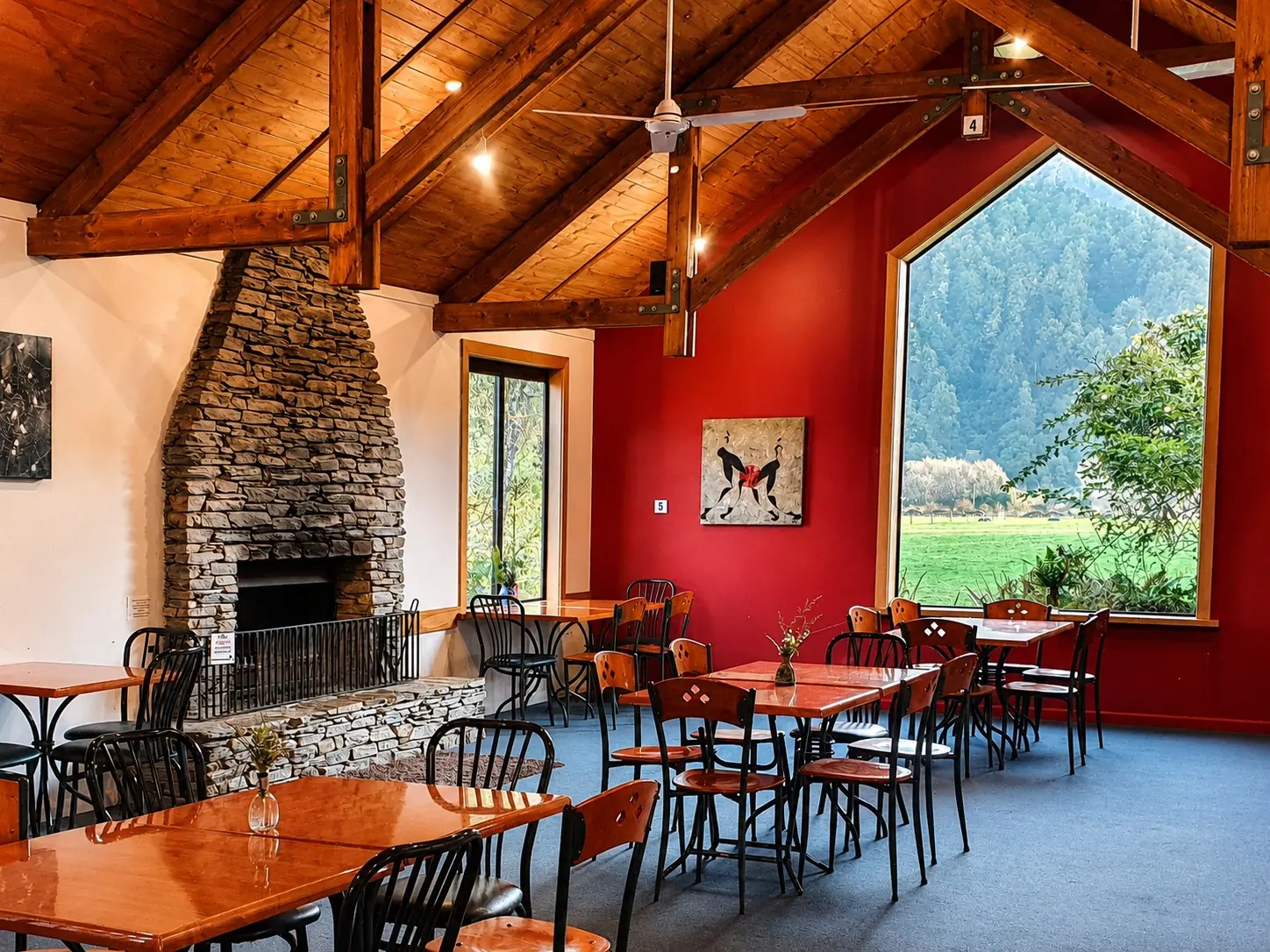 Dining room with a stone fireplace and a large valley-view window