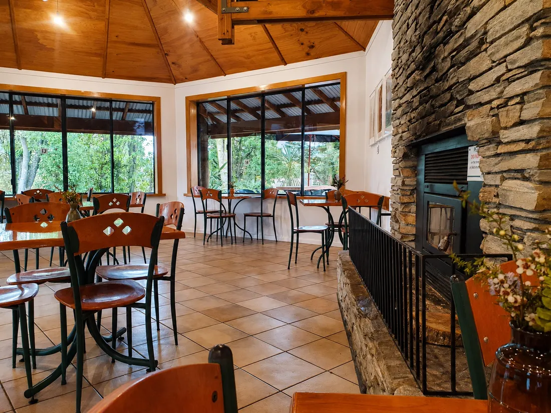 The timber and stone interior of Beechwoods Café, with a fireplace and valley view
